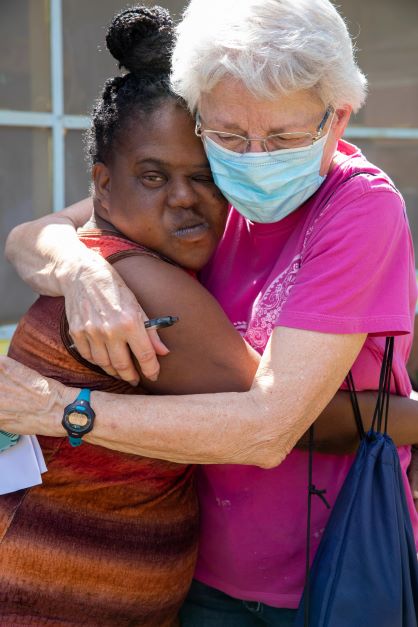 Mission volunteer hugs resident